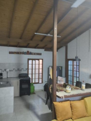sala de estar con mesa y cocina en Cabañas villa Luz, en Armenia