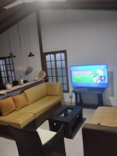 sala de estar con sofá y TV de pantalla plana en Cabañas villa Luz, en Armenia