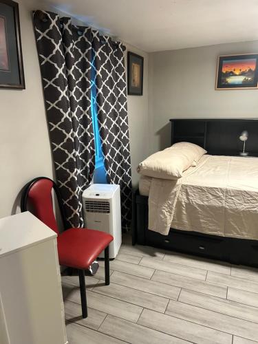 a bedroom with a bed and a red chair at ULTRA COZY CASITA BY DTWN PHX in Phoenix
