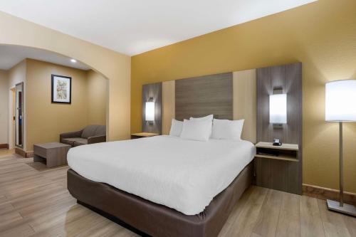 a hotel room with a large bed and a chair at Best Western Plus Springfield Airport Inn in Springfield