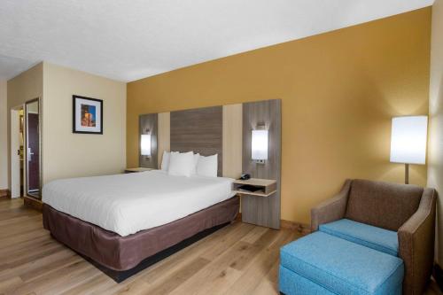 a hotel room with a bed and a chair at Best Western Plus Springfield Airport Inn in Springfield