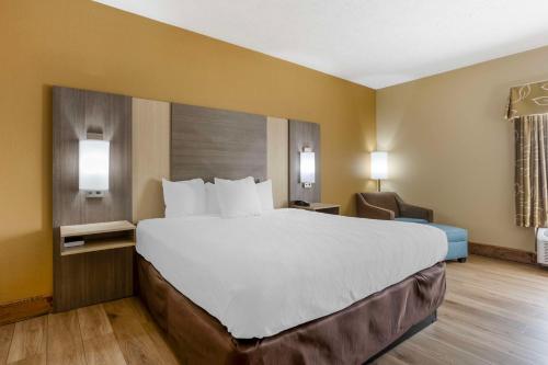 a hotel room with a large bed and a chair at Best Western Plus Springfield Airport Inn in Springfield