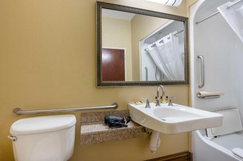 a bathroom with a toilet and a sink and a mirror at Best Western Plus Springfield Airport Inn in Springfield