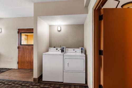 een wasruimte met een witte wasmachine en droger bij Best Western Bridgeview Hotel in Superior