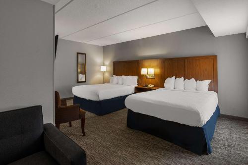 a hotel room with two beds and a couch at Best Western Bridgeview Hotel in Superior