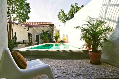 a swimming pool in a backyard with a chair and a chair at Sopas e Descanso in Grândola