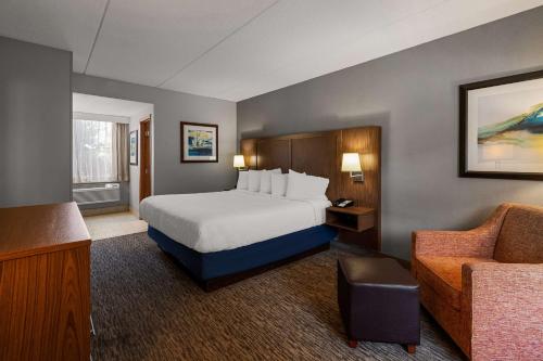 a hotel room with a bed and a chair at Best Western Bridgeview Hotel in Superior