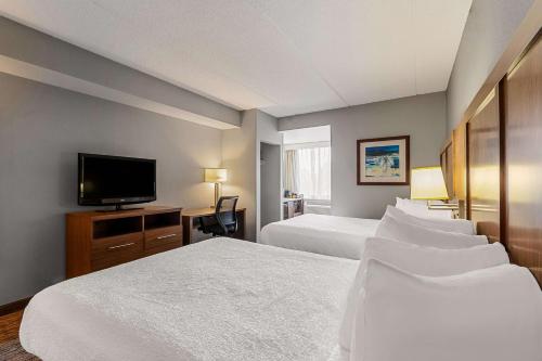 a hotel room with two beds and a flat screen tv at Best Western Bridgeview Hotel in Superior