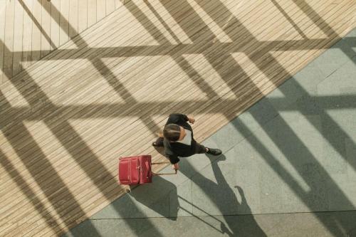 a man walking down a street with a red suitcase at Radisson Blu Airport Terminal Hotel in Arlanda