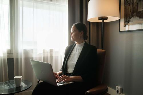 a woman sitting in a chair with a laptop at Radisson Blu Airport Terminal Hotel in Arlanda