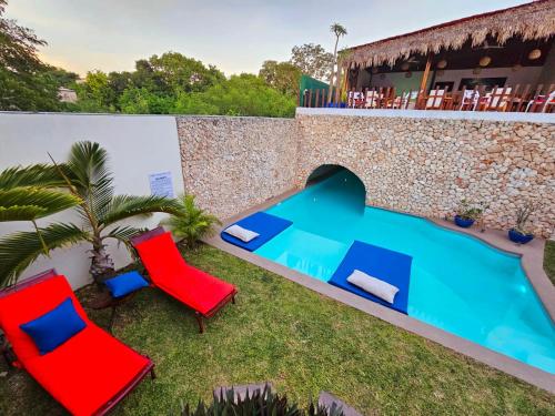 a backyard with two chairs and a swimming pool at Mayan Majesty Boutique Hotel in Valladolid