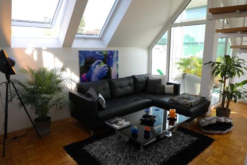 a living room with a black couch and a table at Modern luxury duplex in Düsseldorf-Benrath in Düsseldorf