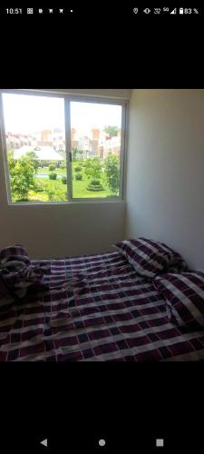 uma cama num quarto com uma grande janela em Casa Xochitepec Morelos em Xochitepec