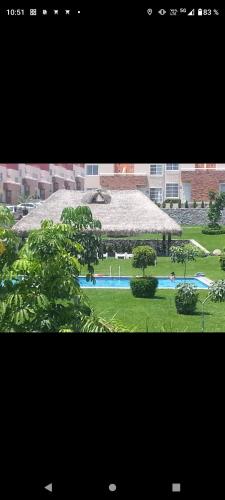uma vista para um edifício com piscina e árvores em Casa Xochitepec Morelos em Xochitepec