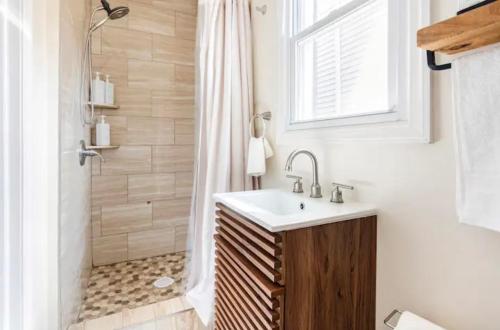 een badkamer met een wastafel en een douche bij Cozy House 20 min to NYC up to 8 People in Fairview