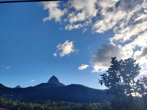 a view of a mountain under a cloudy sky at The Ultimate Escape in Soufrière