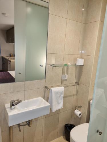 ein Badezimmer mit einem Waschbecken, einem WC und einem Spiegel in der Unterkunft Melbourne ViVo in Melbourne