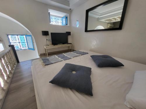 a bedroom with a large bed with two pillows on it at Loft au village de sidi bou said in Sidi Bou Saïd