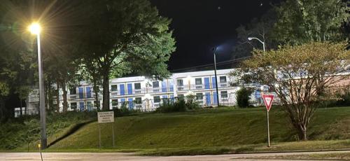 a white building with blue windows and a street light at Lanett Inn in Lanett