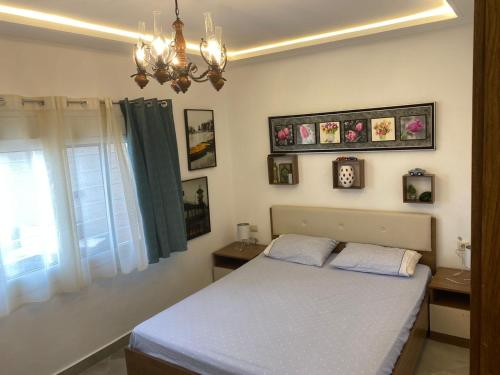 1 dormitorio con cama y lámpara de araña en Mellalyène, en Tetuán