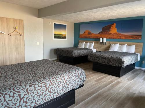 ein Hotelzimmer mit 2 Betten und einem Gemälde an der Wand in der Unterkunft Days Inn by Wyndham Warrensburg in Warrensburg