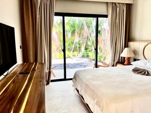 um quarto com uma cama e uma porta de vidro deslizante em Kaikai Beach House, un lujo en el Caribe em Las Terrenas