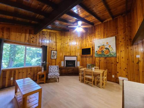 a living room with wooden walls and a table and a television at Fern River Resort in Felton