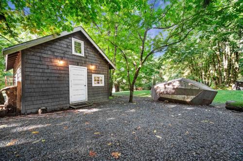 um pequeno barracão com uma porta branca num quintal em Sunwolf Riverside Cabins em Brackendale