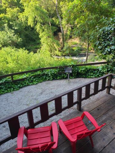 two red chairs sitting on a wooden bench at Fern River Resort in Felton