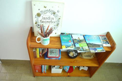 uma estante de livros com livros e uma mesa com livros em Mola-Mola Sagres em Sagres