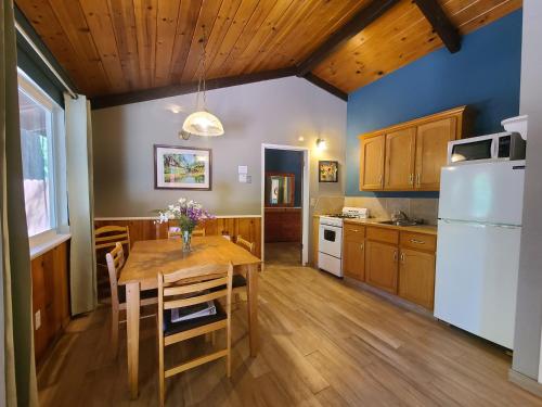 a kitchen with a wooden table and a refrigerator at Fern River Resort in Felton