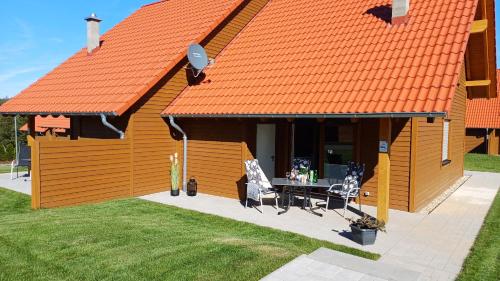 an orange roof on a house with a table and chairs at Premiumhaus Hygge in Hasselfelde
