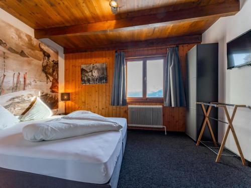 een slaapkamer met een groot bed en een raam bij Chalet H XL in Königsleiten