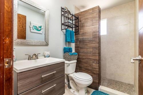a bathroom with a toilet and a sink and a mirror at Rosarito Chic Escape*King Bed*Wi-Fi*Pool*BBQ*3 Gardenhaus in Tijuana