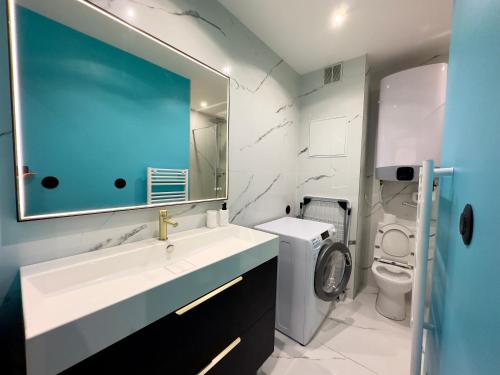 La salle de bains est pourvue d'un lavabo, de toilettes et d'un miroir. dans l'établissement Los Angeles, à Villeurbanne