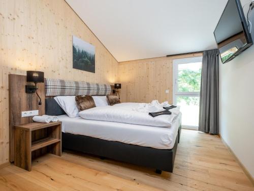 a bedroom with a large bed and a tv at Goldstern in Sankt Lorenzen ob Murau