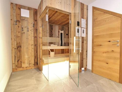La salle de bains est pourvue d'une douche en verre et de murs en bois. dans l'établissement Goldstern, à Sankt Lorenzen ob Murau