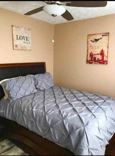 Bett in einem Schlafzimmer mit Deckenventilator in der Unterkunft Carl Nespoli in Fayetteville