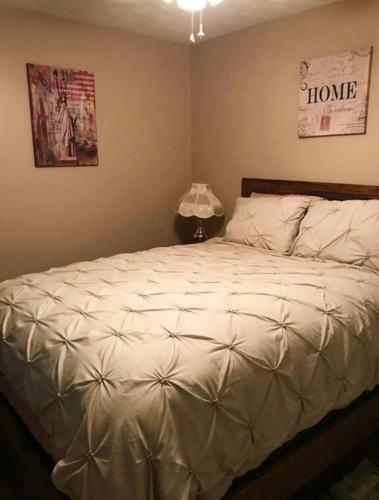 ein Schlafzimmer mit einem Bett mit einer weißen Bettdecke in der Unterkunft Carl Nespoli in Fayetteville
