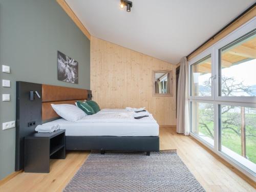 um quarto com uma cama e uma grande janela em Aquarius Haus 7 TOP 16 em Sankt Lorenzen ob Murau