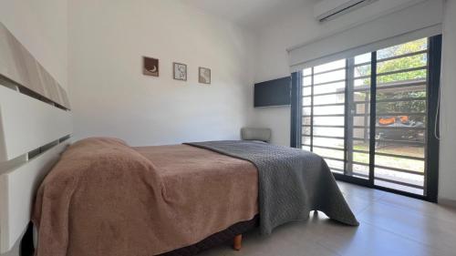 a bedroom with a bed and a large window at Depto SomoS in Colón