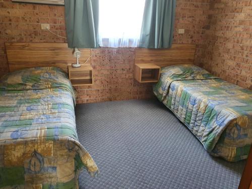 a bedroom with two twin beds and a window at Alyn Motel in Gunnedah