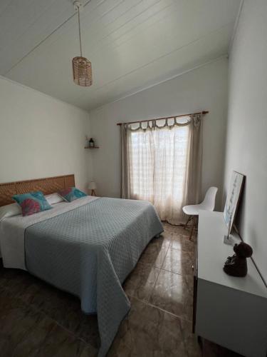Schlafzimmer mit einem Bett, einem Tisch und einem Fenster in der Unterkunft CASA ARENA en la Rambla, frente a la playa ,para 4 personas in Colonia del Sacramento