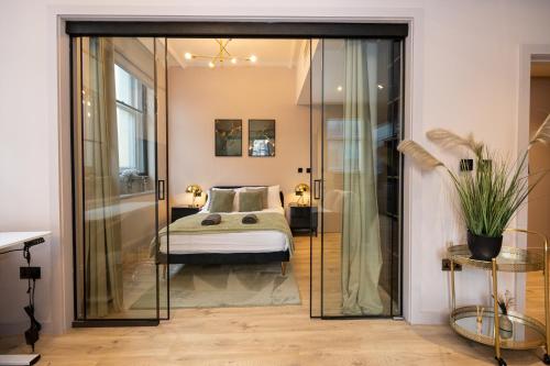 a bedroom with a bed and a glass door at Luxury 2BR Apt In City Centre in Manchester
