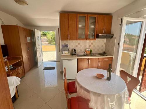 a kitchen with a table with a white table cloth on it at Apartments by the sea Sali, Dugi otok - 8110 in Sali