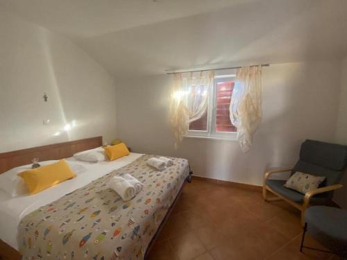 sypialnia z łóżkiem, krzesłem i oknem w obiekcie Apartments by the sea Sali, Dugi otok - 8110 w mieście Sali
