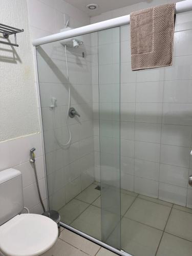 a bathroom with a glass shower with a toilet at Flat B306 Village Aldeia das Águas in Barra do Piraí