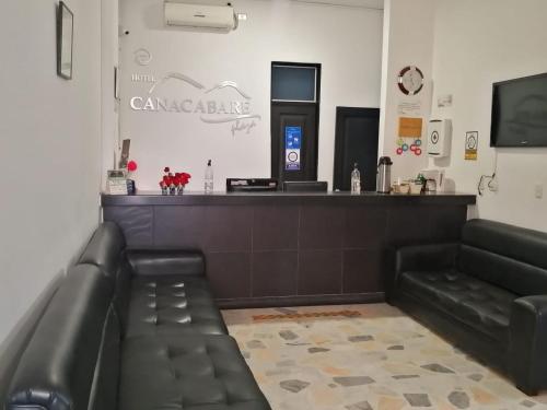 a waiting room with a couch in front of a counter at Hotel Canacabare Plaza in Yopal