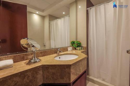 a bathroom with a sink and a large mirror at Spacious 2BR near MOE - 2 Min Drive in Dubai
