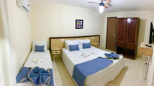 1 dormitorio con 2 camas con sábanas azules y blancas en Pousada Mar Da Barra, en Maragogi